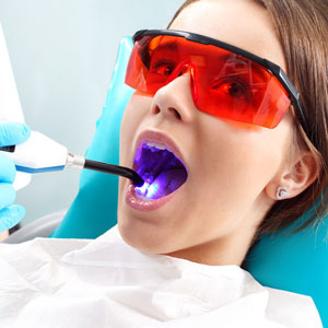 Entspannte Patientin wird mit einem Dentallaser behandelt